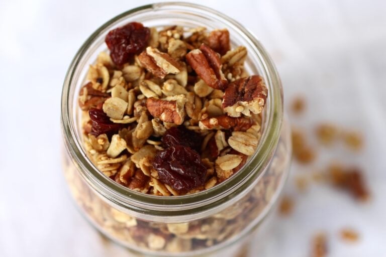 Close up view of Cherry Pecan Quinoa Granola in a glass jar. 