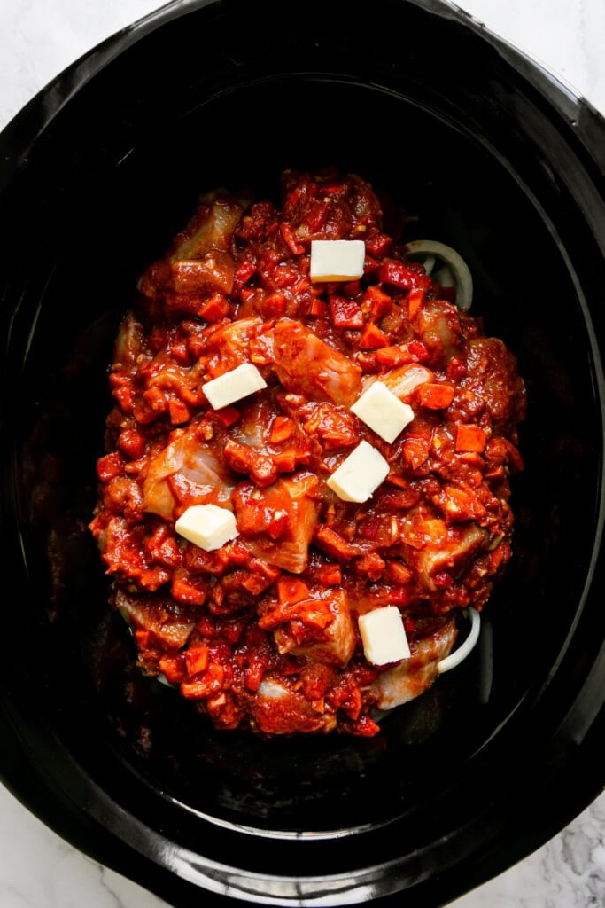 Overhead view of Butter Chicken ingredients in a crockpot ready for cooking. 